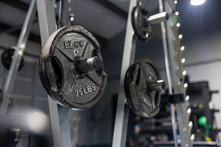 Weight plates on a gym rack, with a 25-lb plate in focus at 360 image fitness gym