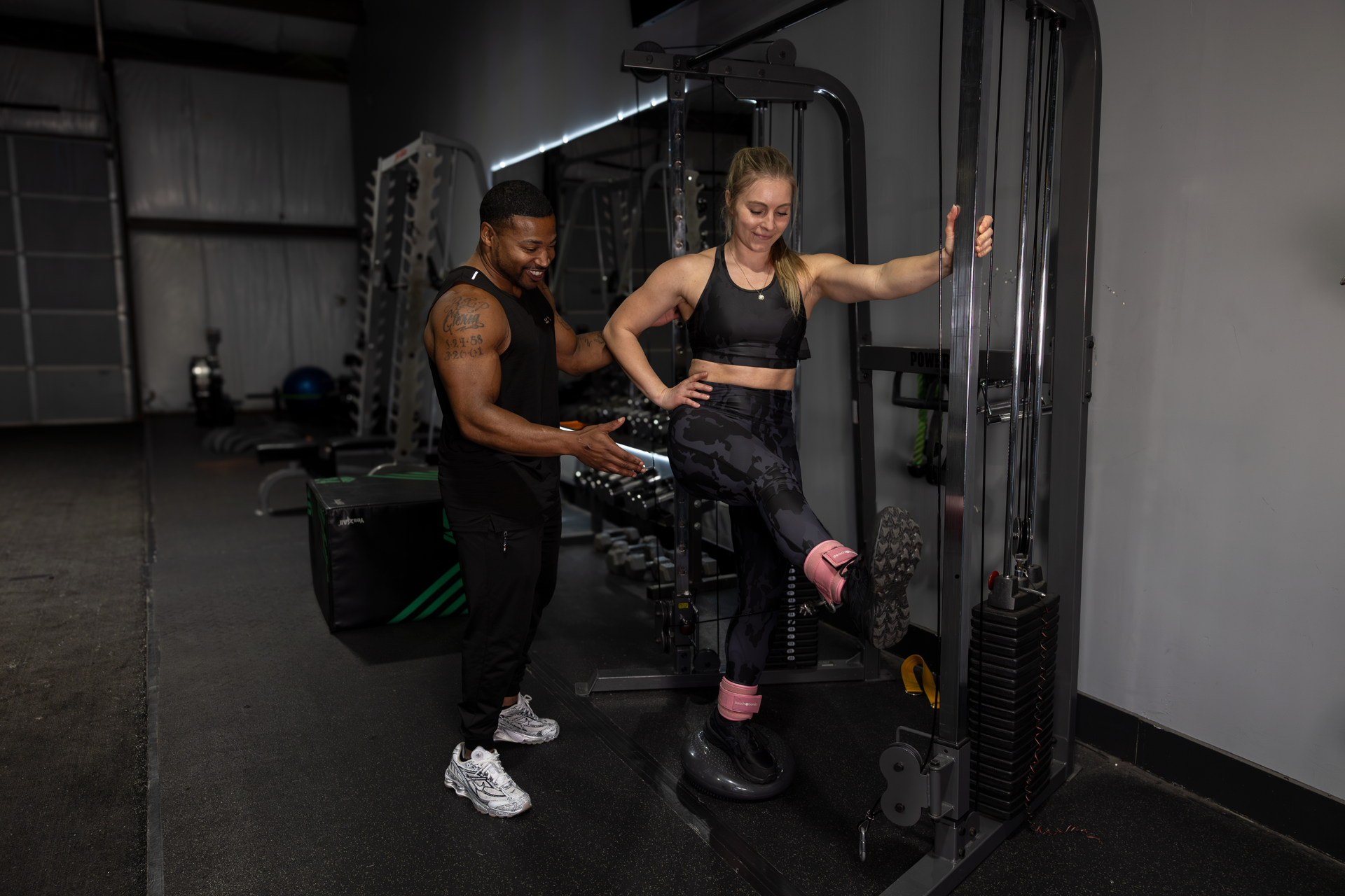 Trey Johnson at 360 Image Fitness gym in Watkinsville, GA helping female client with leg strengthening with gym equipment