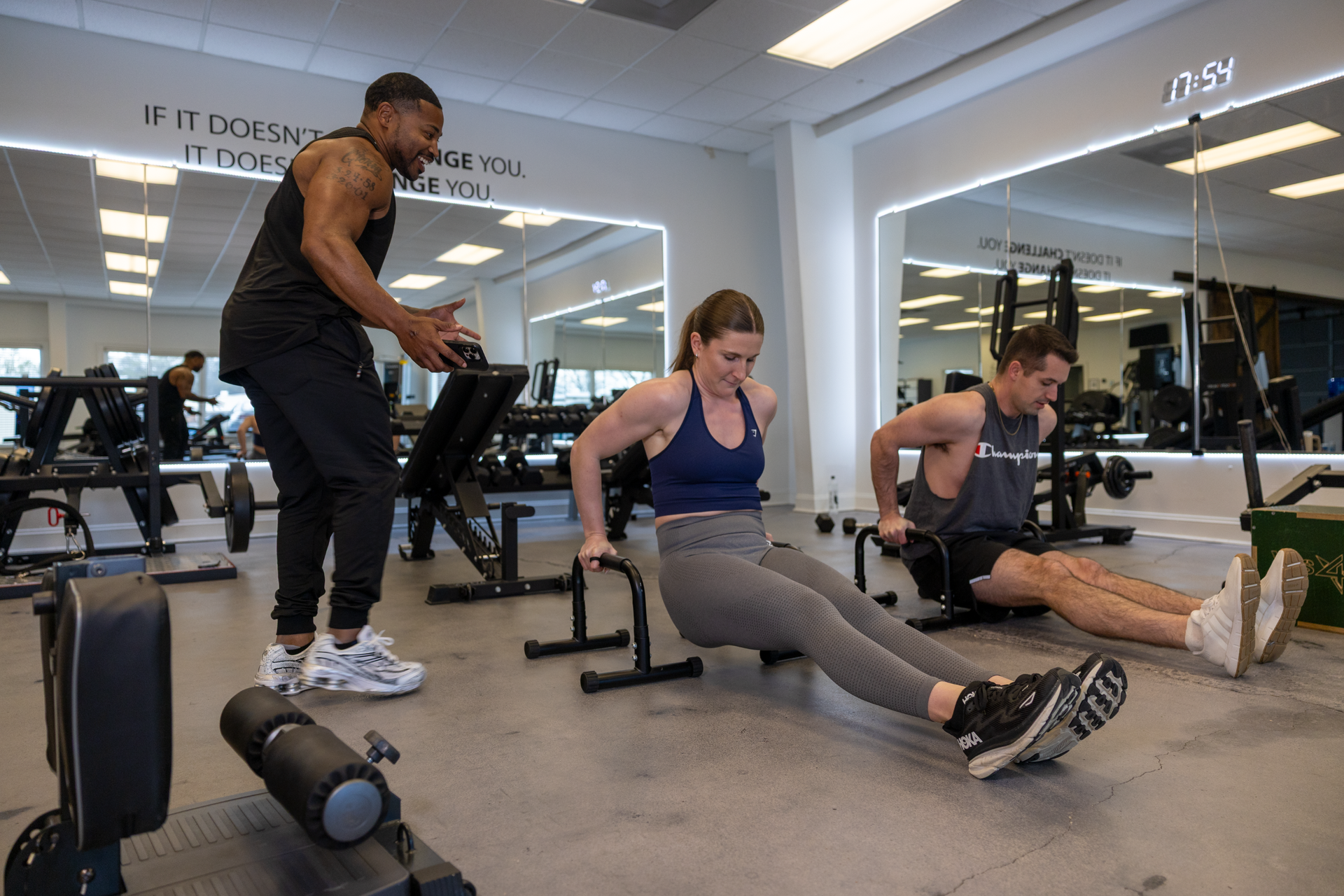 Trainer Trey Johnson at 360 Image Fitness gym in Watkinsville, GA helping female client with arm dip strengthening exercises