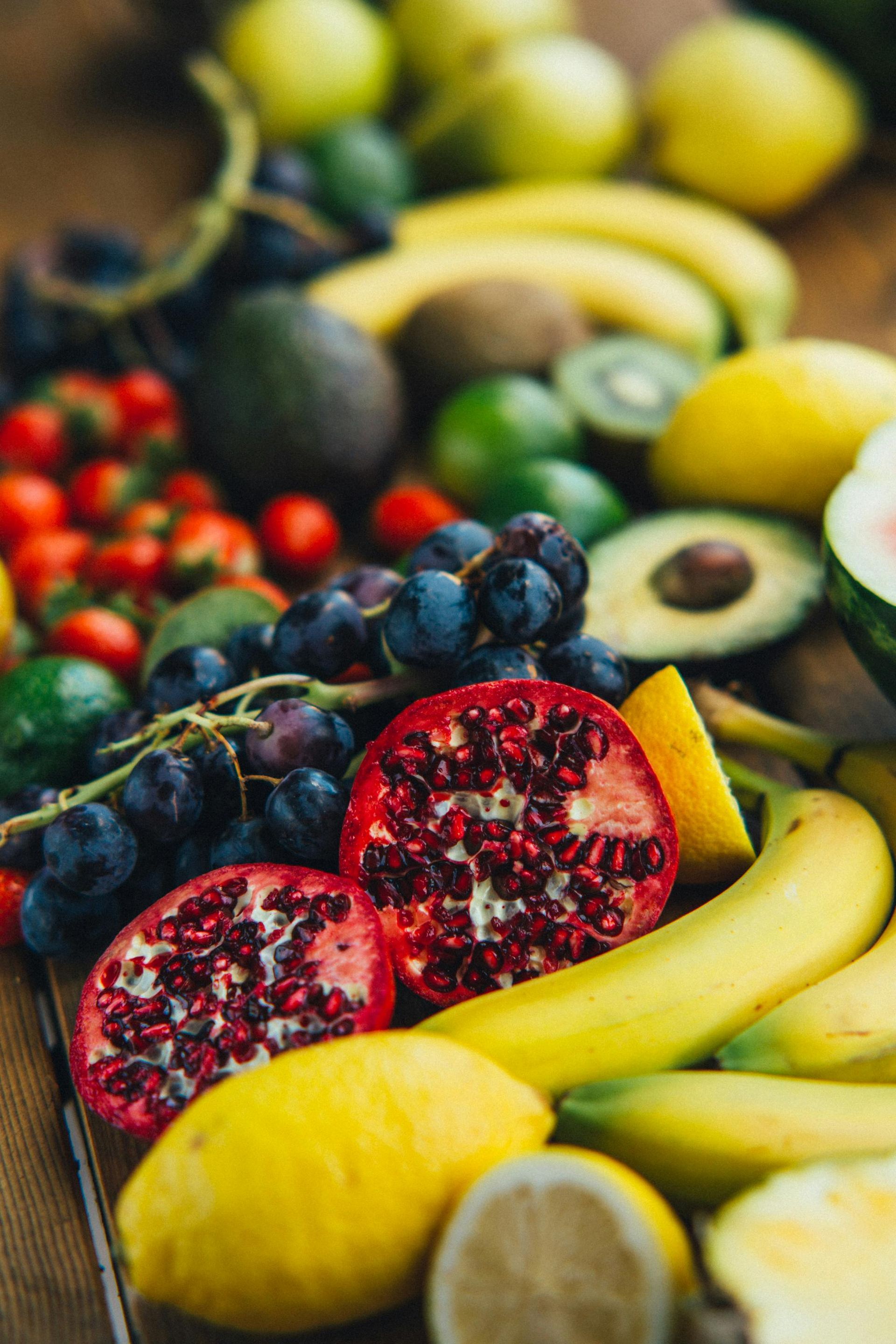 Assorted fresh fruits including bananas, avocados, pomegranates, lemons, and berries arranged on display for 360 image  gym