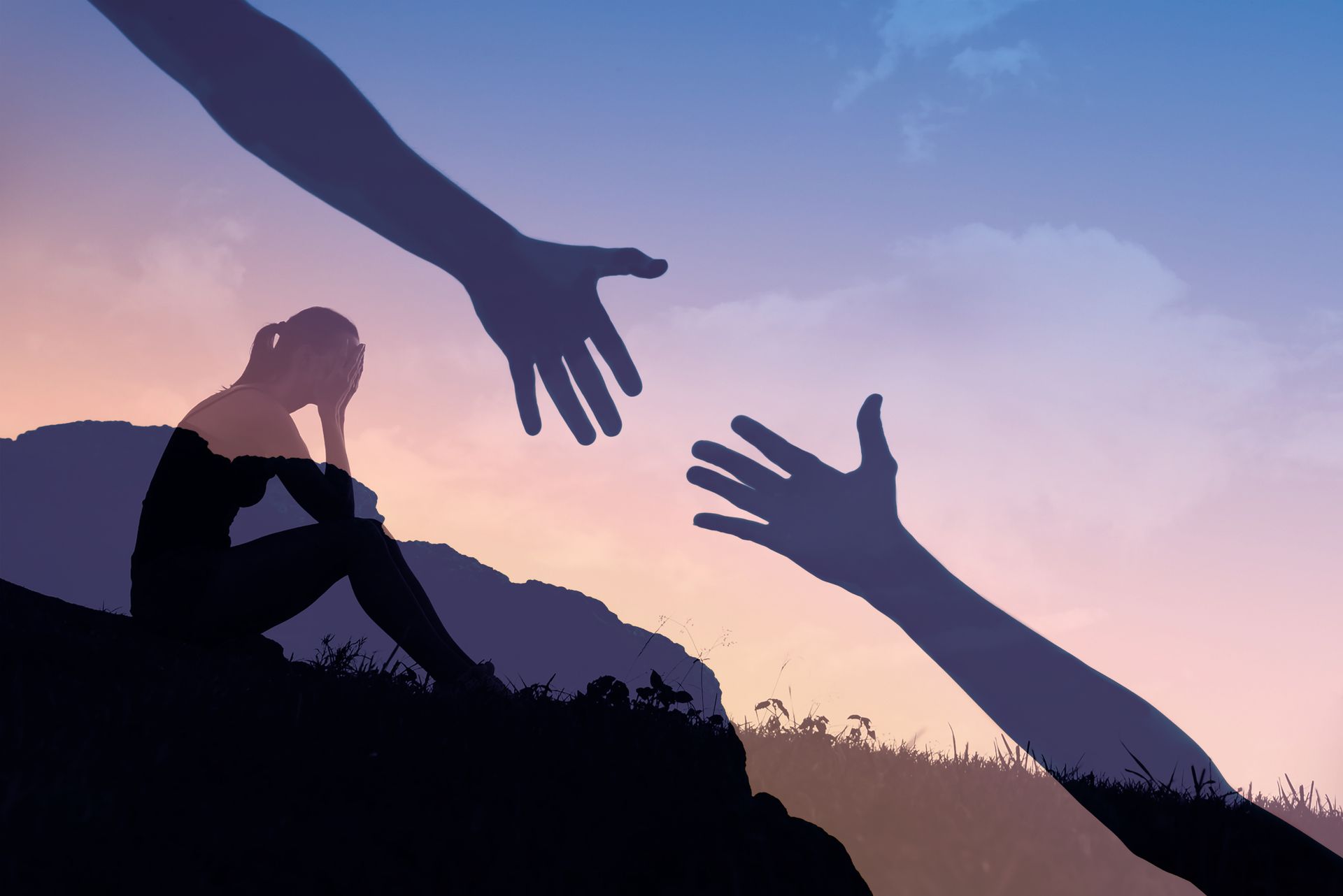 Silhouette of a person in distress on a mountain, with hands reaching out to help against a sunset backdrop.