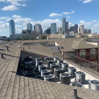 A rooftop with a city skyline in the background with aircon installed
