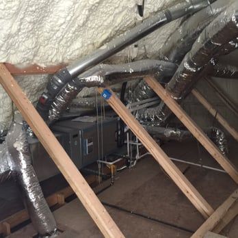 A room with a lot of aircon pipes and ducts in it