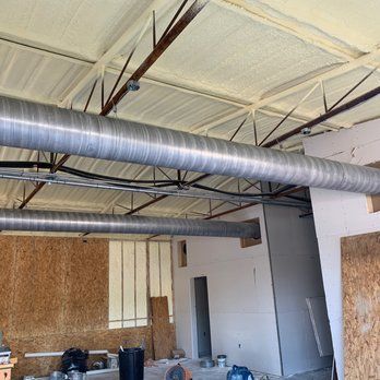 A large aircon pipes is hanging from the ceiling of a building.