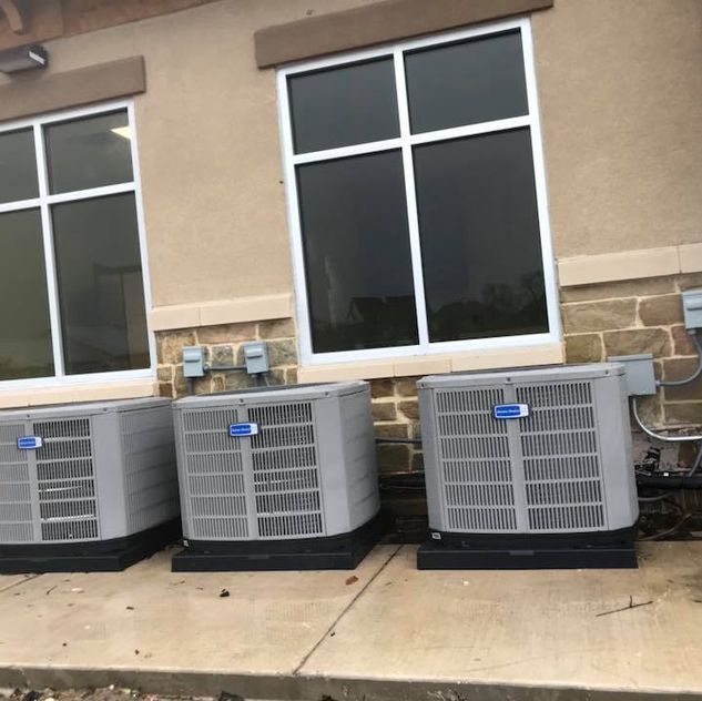 Three air conditioners are sitting outside of a building