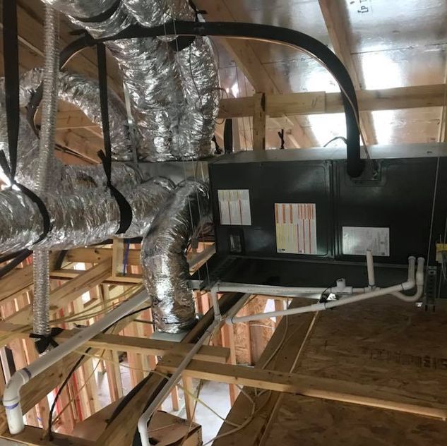 A ceiling with a lot of aircon pipes and wires hanging from it