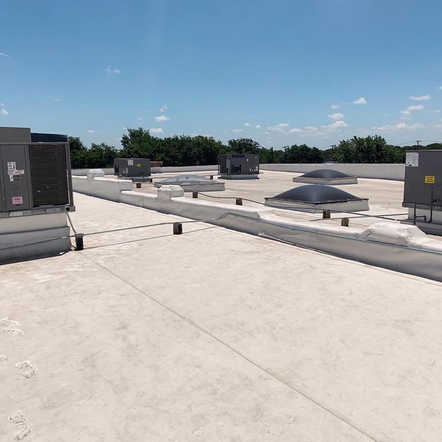 The roof of a building with a lot of air conditioners on it.