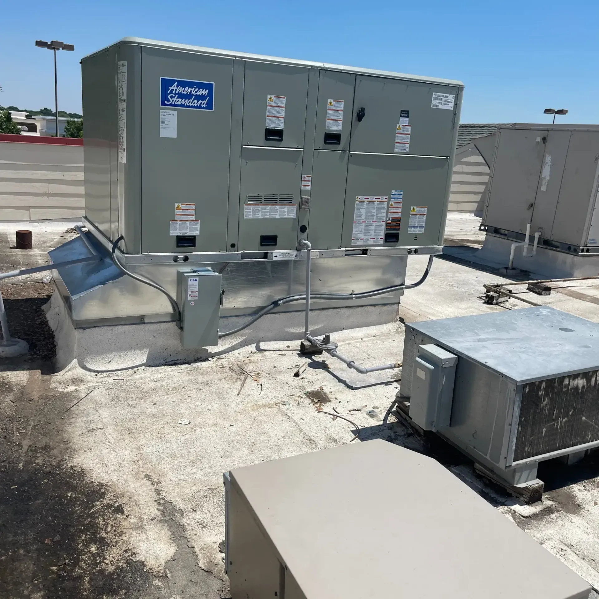 Raymond Lopez Services, LLC. Heating & Air - A large gray box with a blue sign that says ' atrium standard ' on it