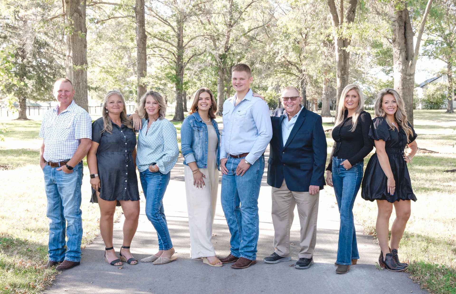 Nichols Real Estate team smiling in front of horse racing banner against a blank white wall