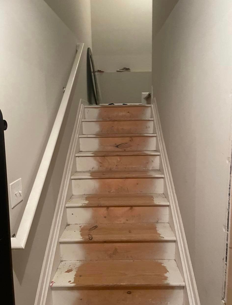 A staircase with wooden steps and a white railing in a room.