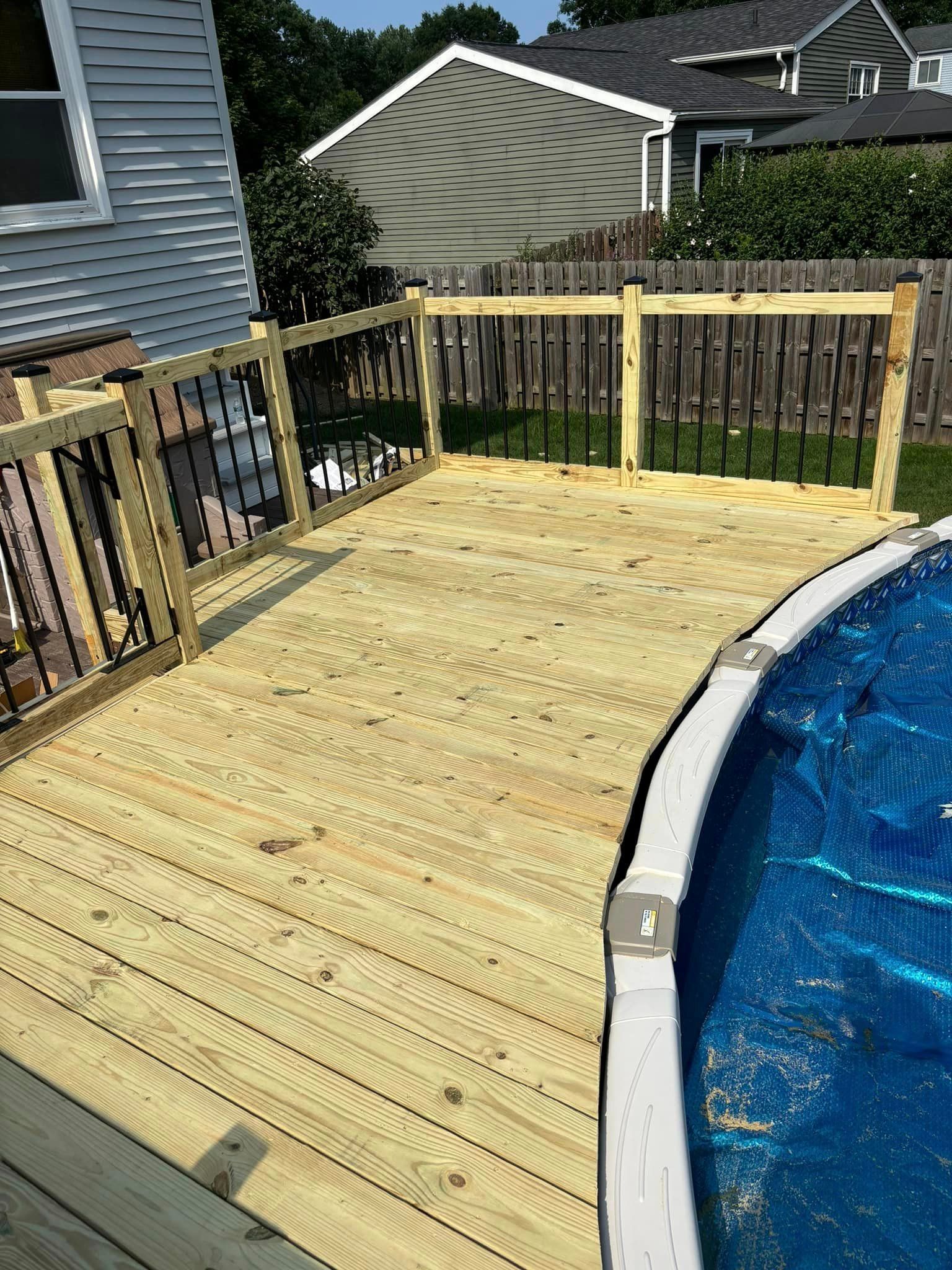 There is a wooden deck next to a swimming pool.