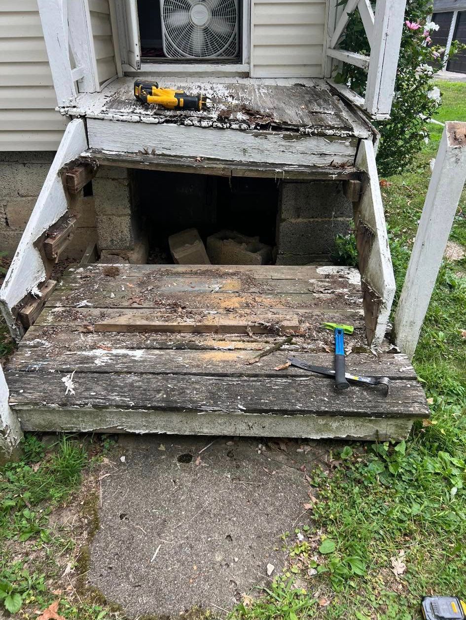 A wooden porch with a hole in it is being remodeled.