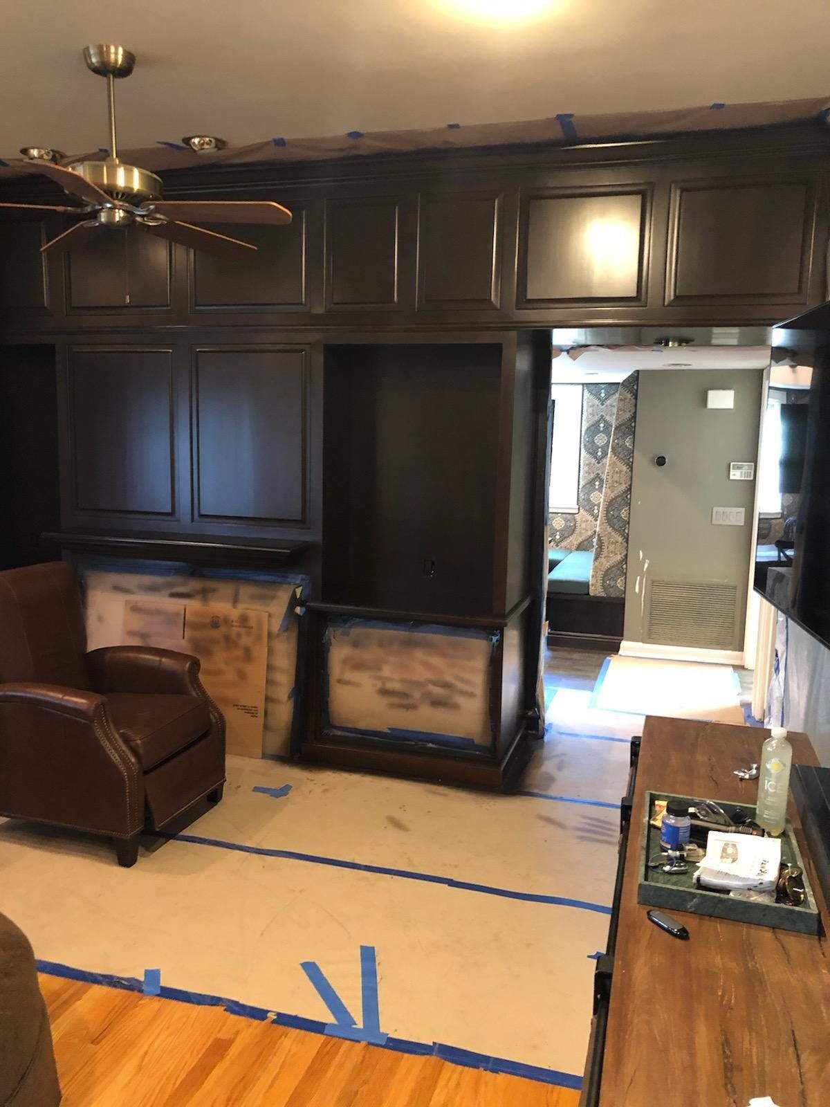 A living room with a chair and a ceiling fan