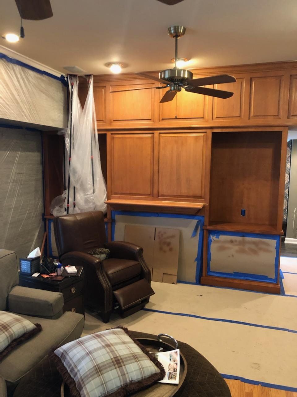 A living room with a chair and a ceiling fan