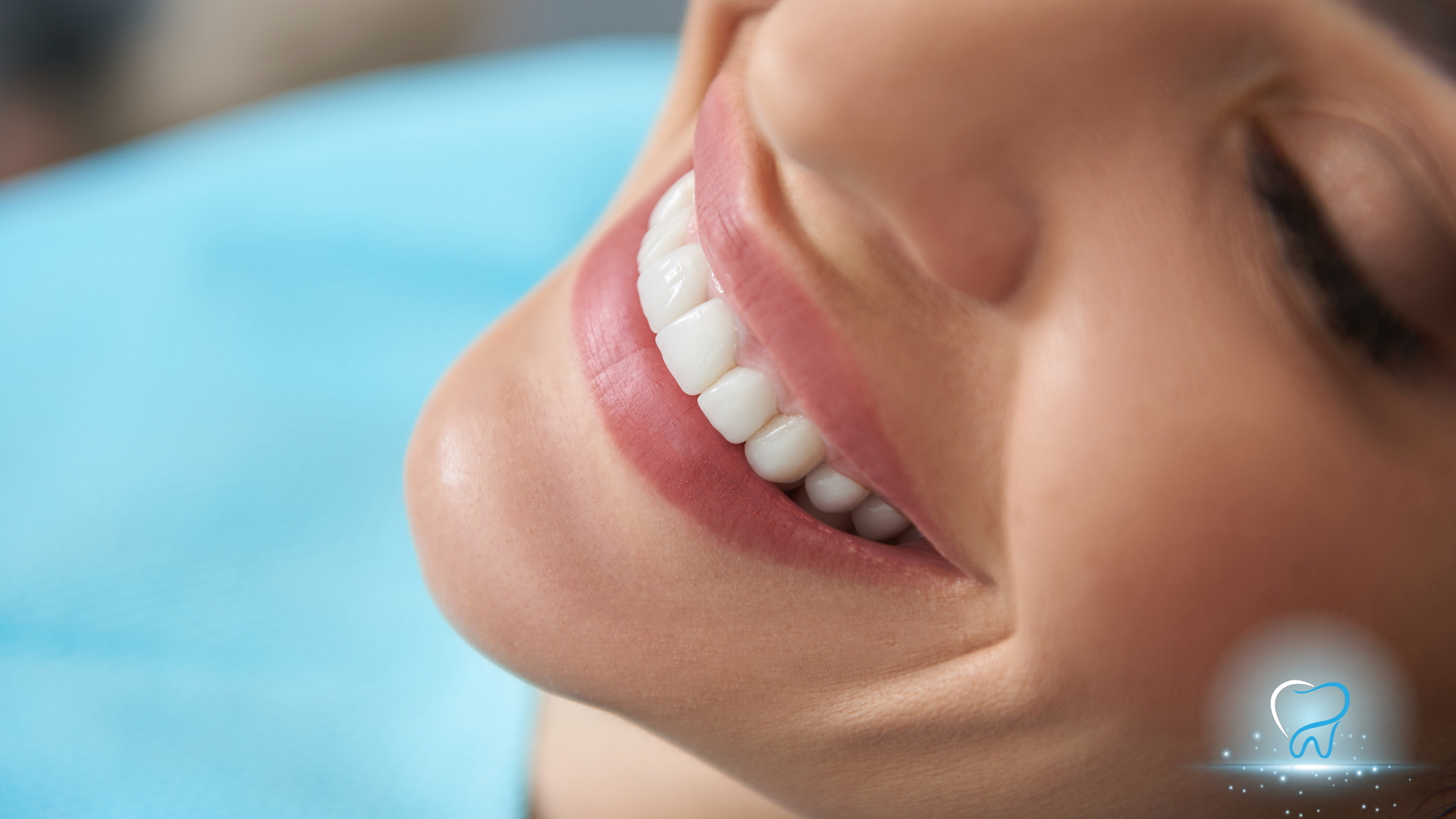 A woman is smiling in a dental chair with her eyes closed.