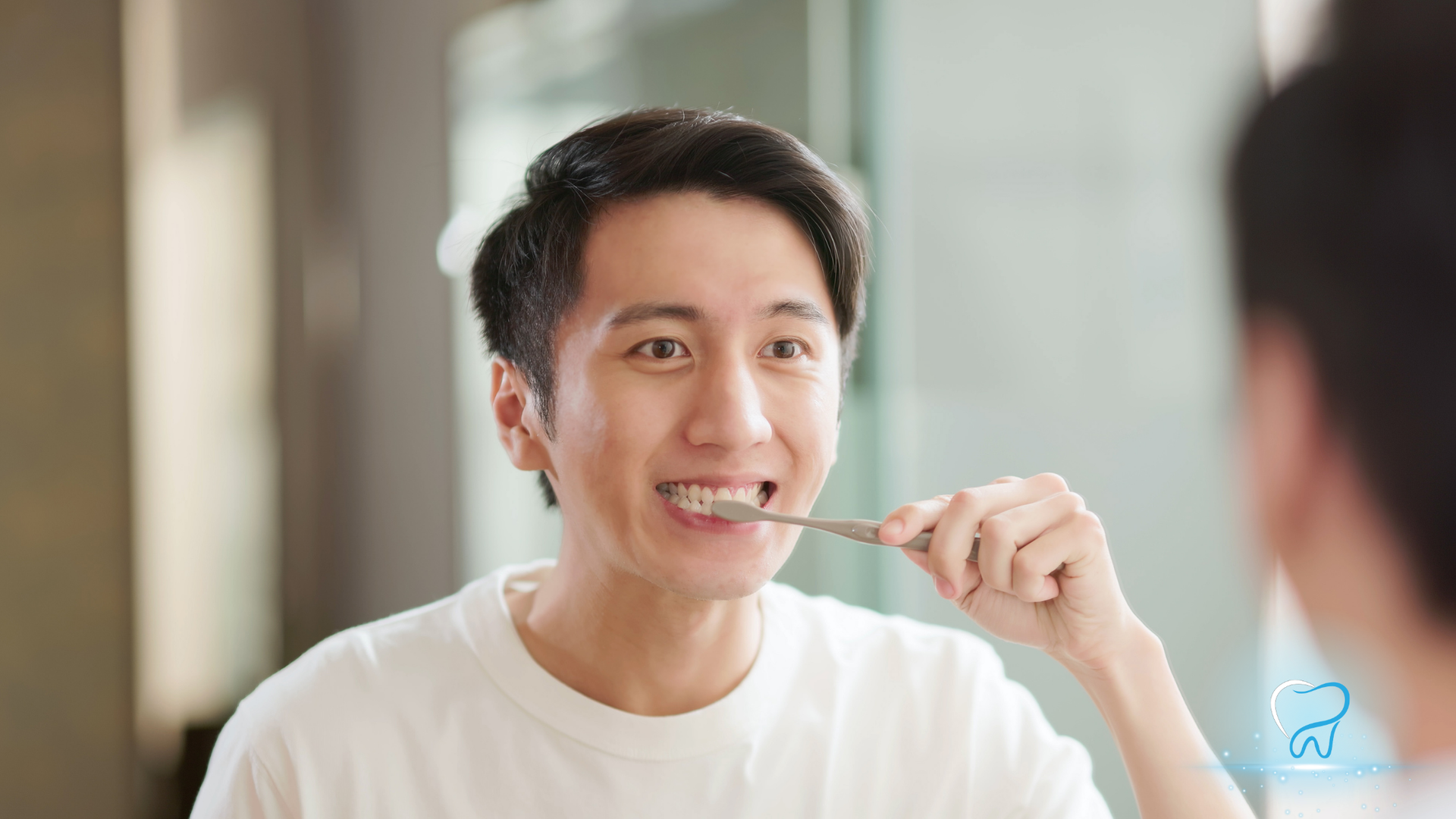 A man is brushing his teeth in front of a mirror.