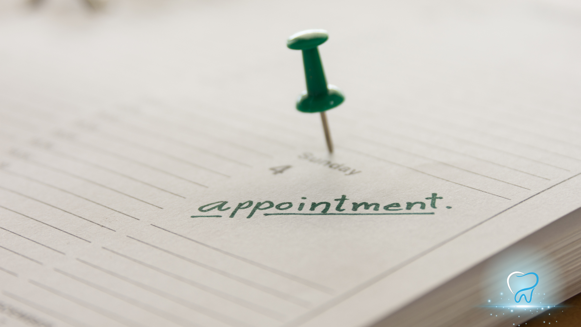 Green pushpin on open book, underlining the word