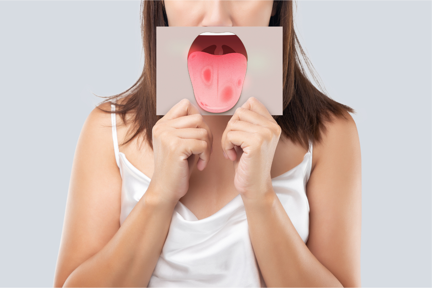 Woman holding a card with a tongue illustration over her face