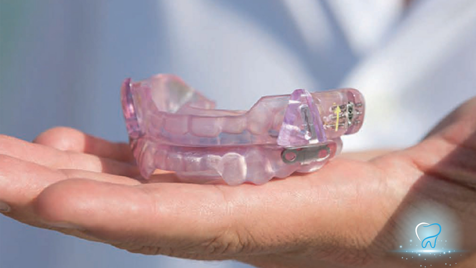 A person is holding a purple mouth guard in their hand.