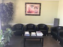 A waiting room with chairs , a table and a picture on the wall.