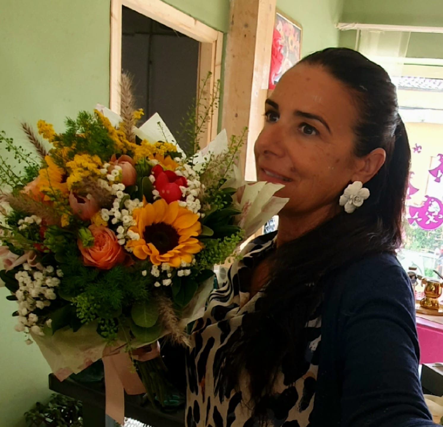 Una finestra mostra una scena d'interno con una lampada e delle piante, vista dall'esterno. La finestra è incorniciata da pareti chiare.