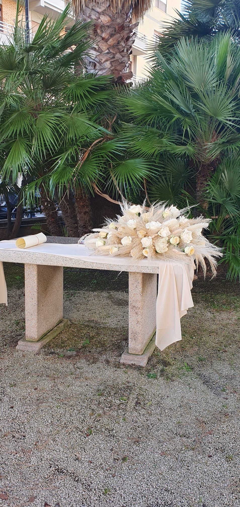 Composizione floreale su un tavolo di legno, con un tappeto intrecciato sul ponte di uno yacht.