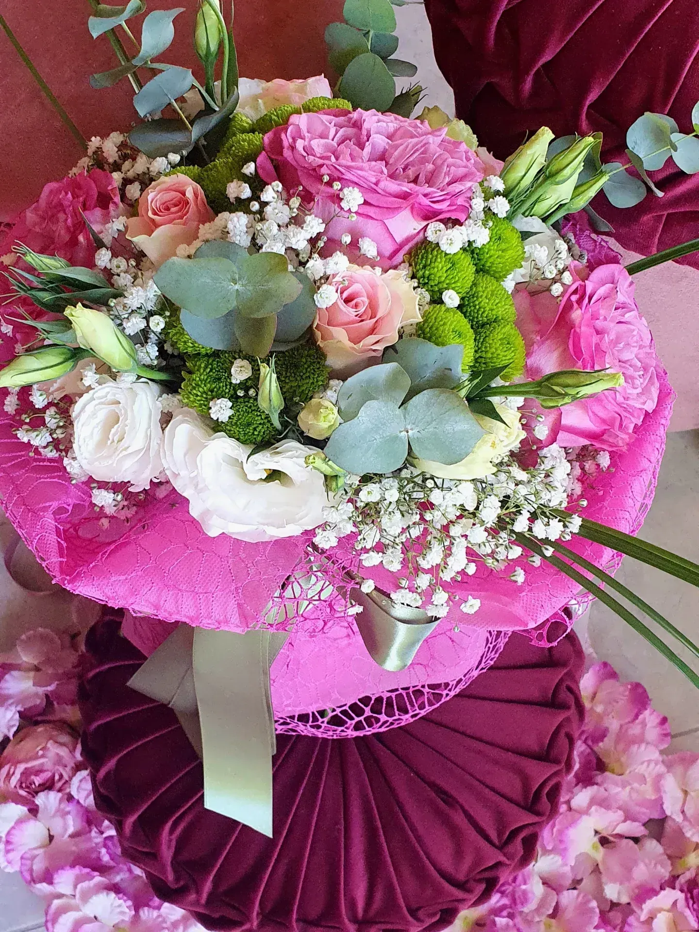 Bouquet di fiori rosa e bianchi con accenti verdi, avvolto in tessuto rosa.
