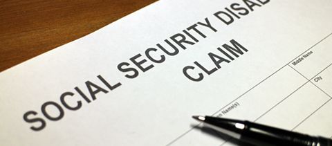 A pen is sitting on top of a social security claim form.