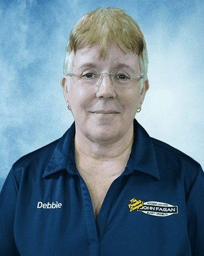 A woman wearing glasses and a blue shirt with the name debbie on it