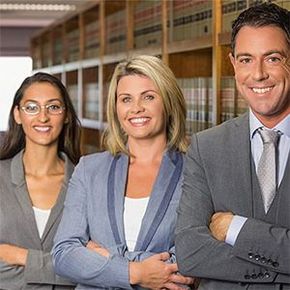 A man and two women are posing for a picture in a library.