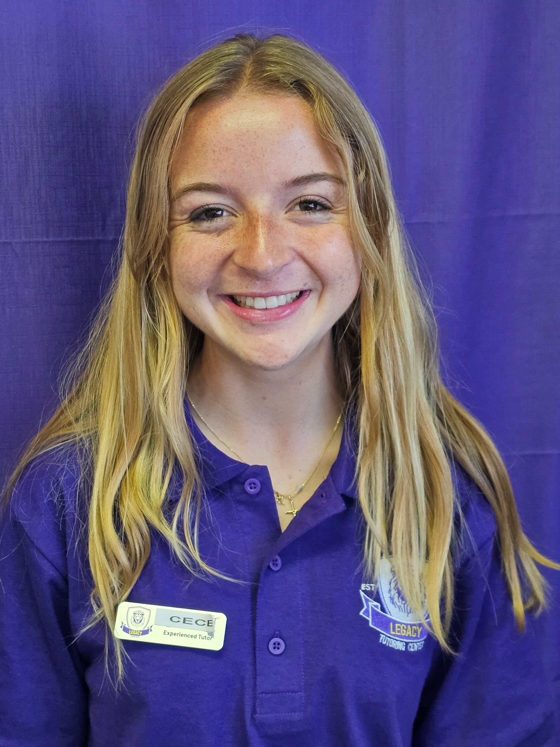 A young woman wearing a purple shirt is smiling for the camera.