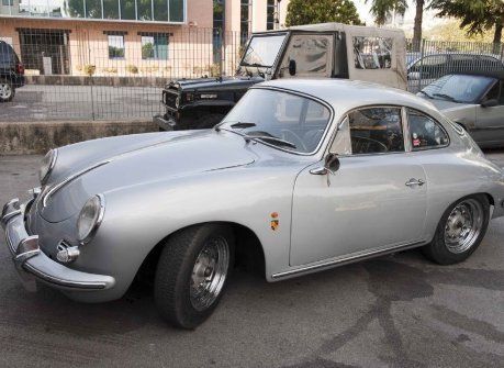 Una porsche argentata è parcheggiata davanti a un edificio