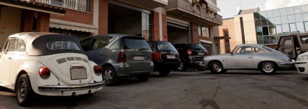 Una fila di auto è parcheggiata davanti a un edificio.