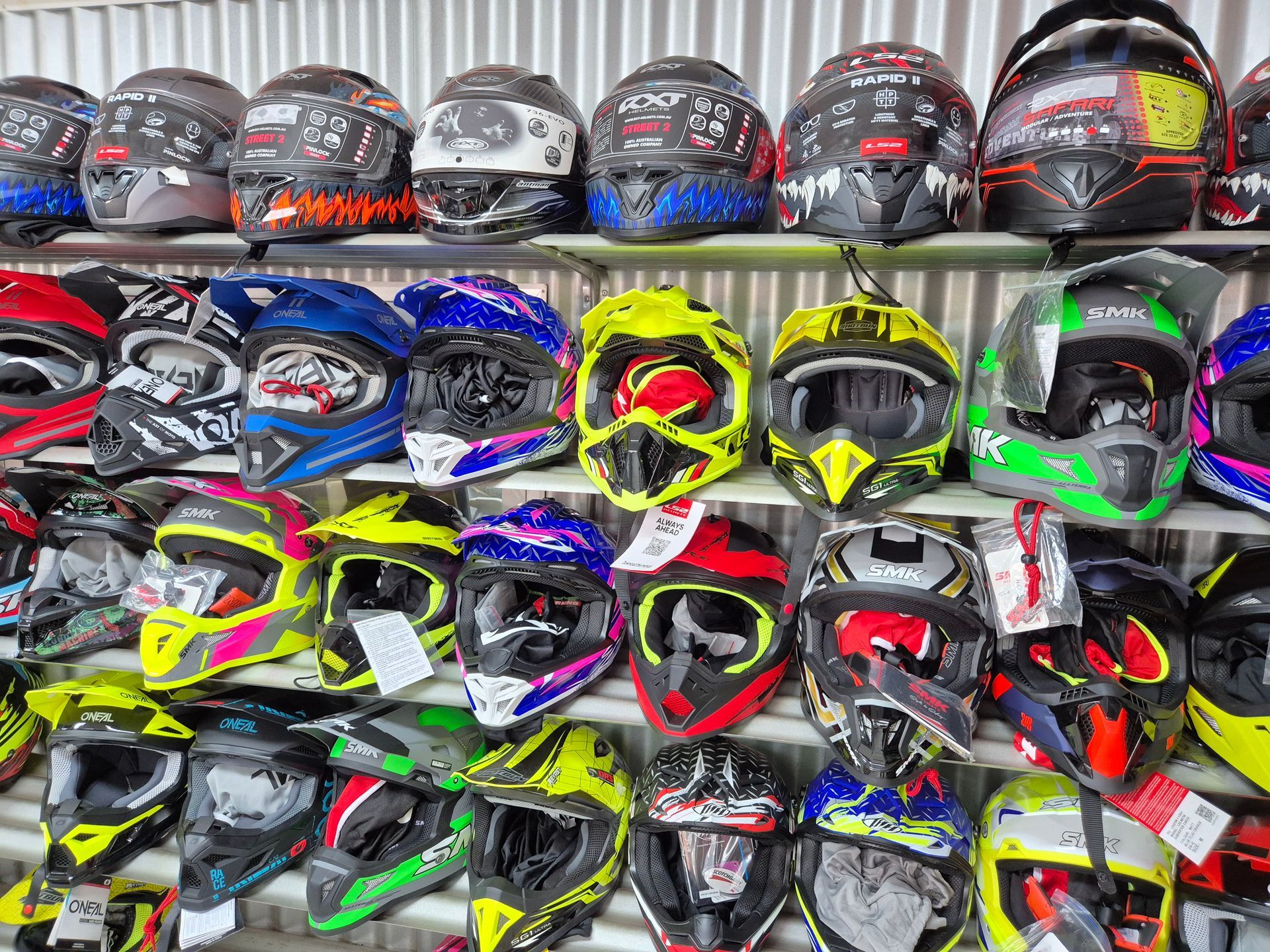 A Bunch of Motorcycle Helmets Are Hanging on a Shelf — R & M Motorcycles in Katherine, NT