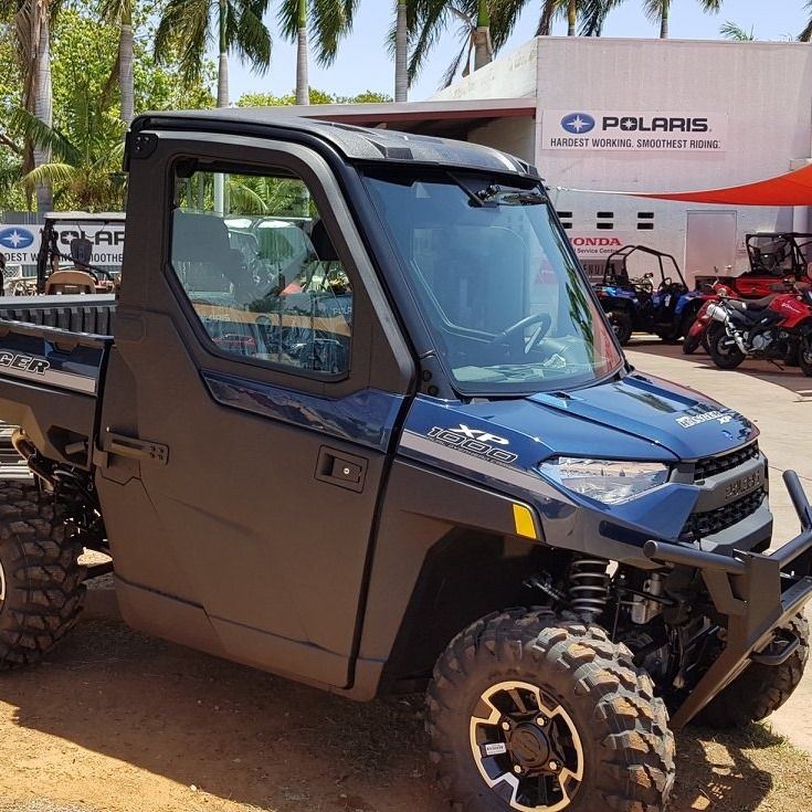 A Row of Four Wheelers Are Parked in a Grassy Field — R & M Motorcycles in Katherine, NT