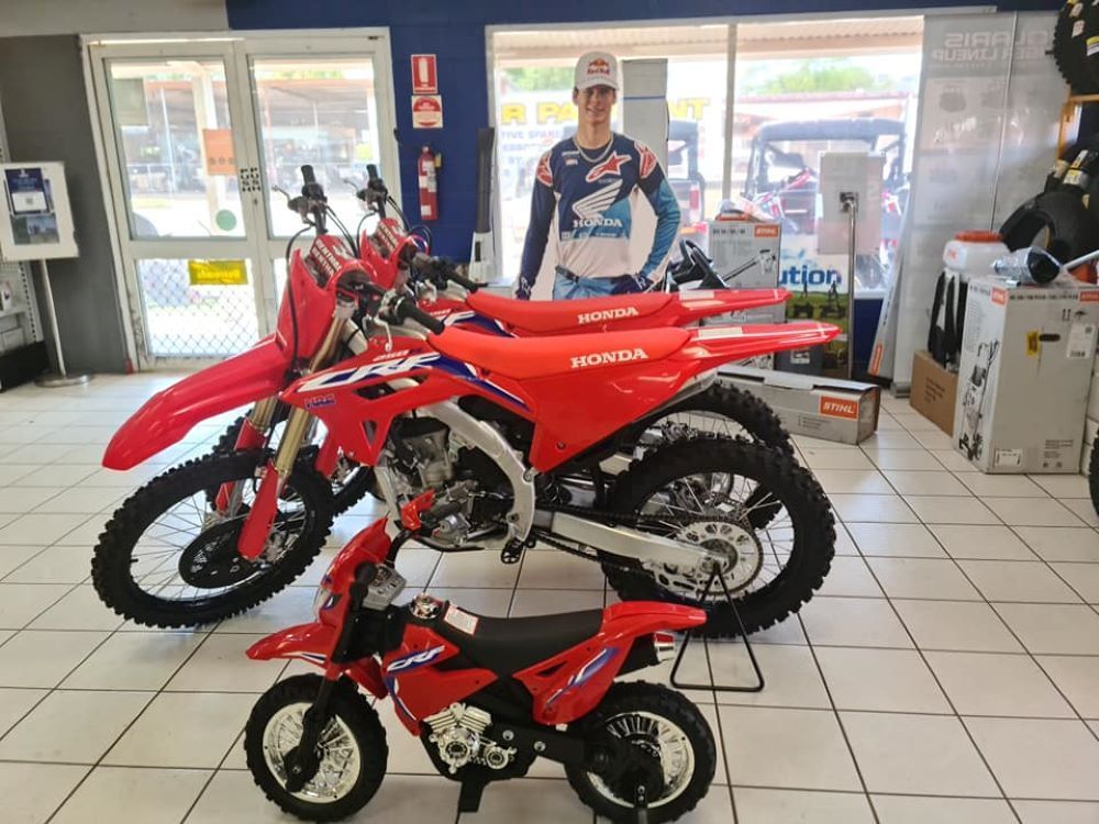 A Man is Standing Next to a Row of Dirt Bikes in a Showroom — R & M Motorcycles in Katherine, NT