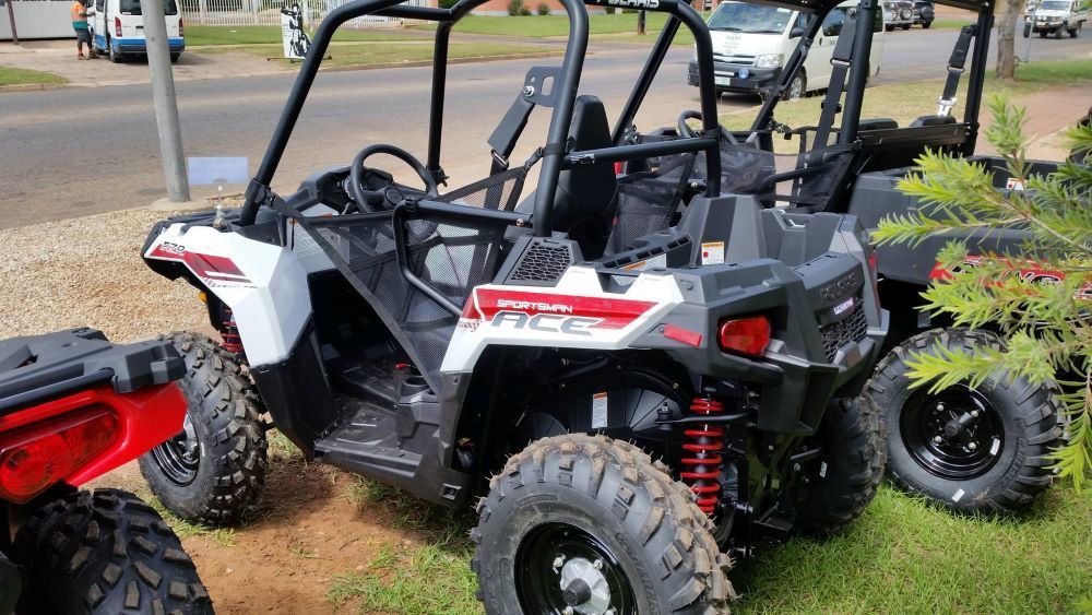 A White ATV is Parked in the Grass Next to a Red ATV — R & M Motorcycles in Katherine, NT