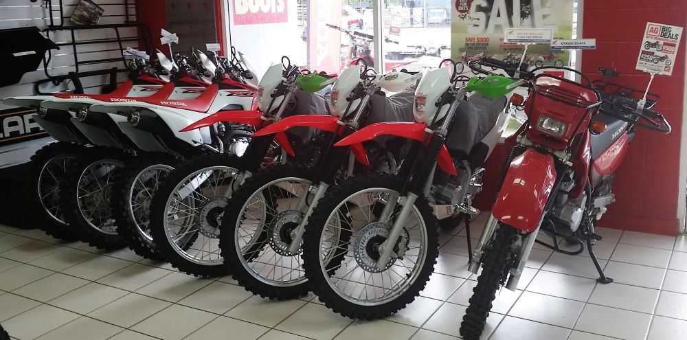A Row of Dirt Bikes Are Lined Up in a Showroom — R & M Motorcycles in Katherine, NT