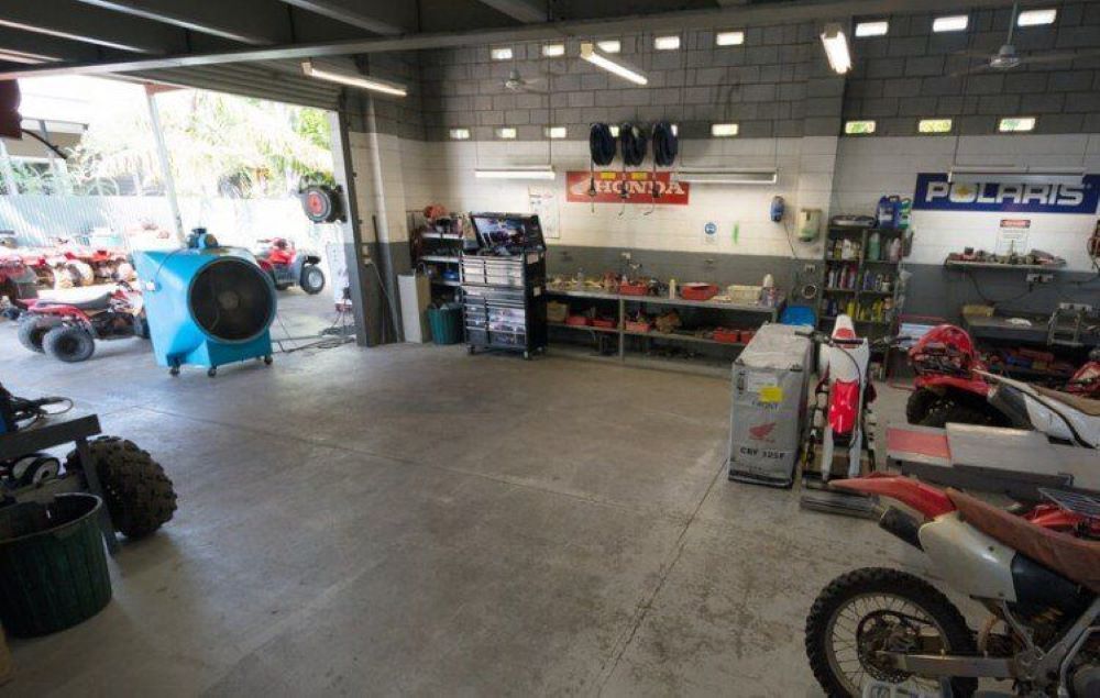 A Motorcycle is Parked in a Garage With a Polaris Sign on the Wall — R & M Motorcycles in Katherine, NT