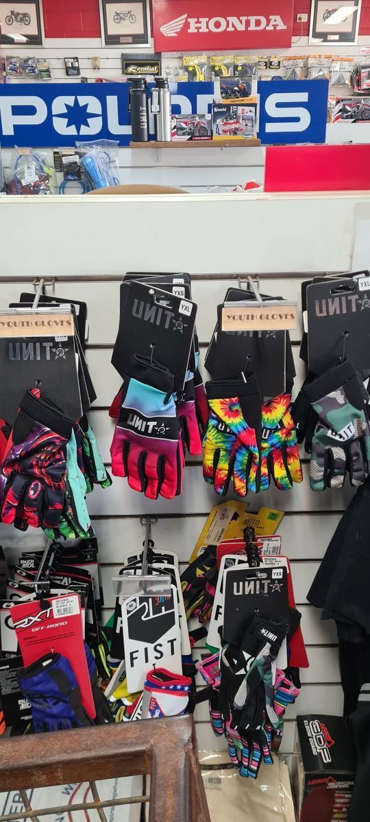 A Bunch of Gloves Are Hanging on a Wall in a Store — R & M Motorcycles in Katherine, NT
