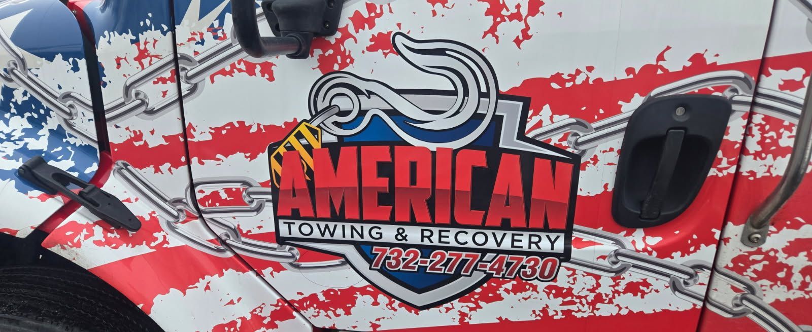 A tow truck side with American flag graphics and 