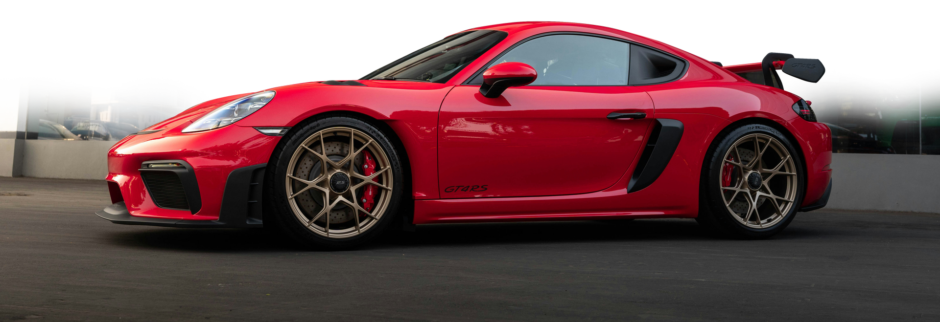 A red sports car is parked in a parking lot.