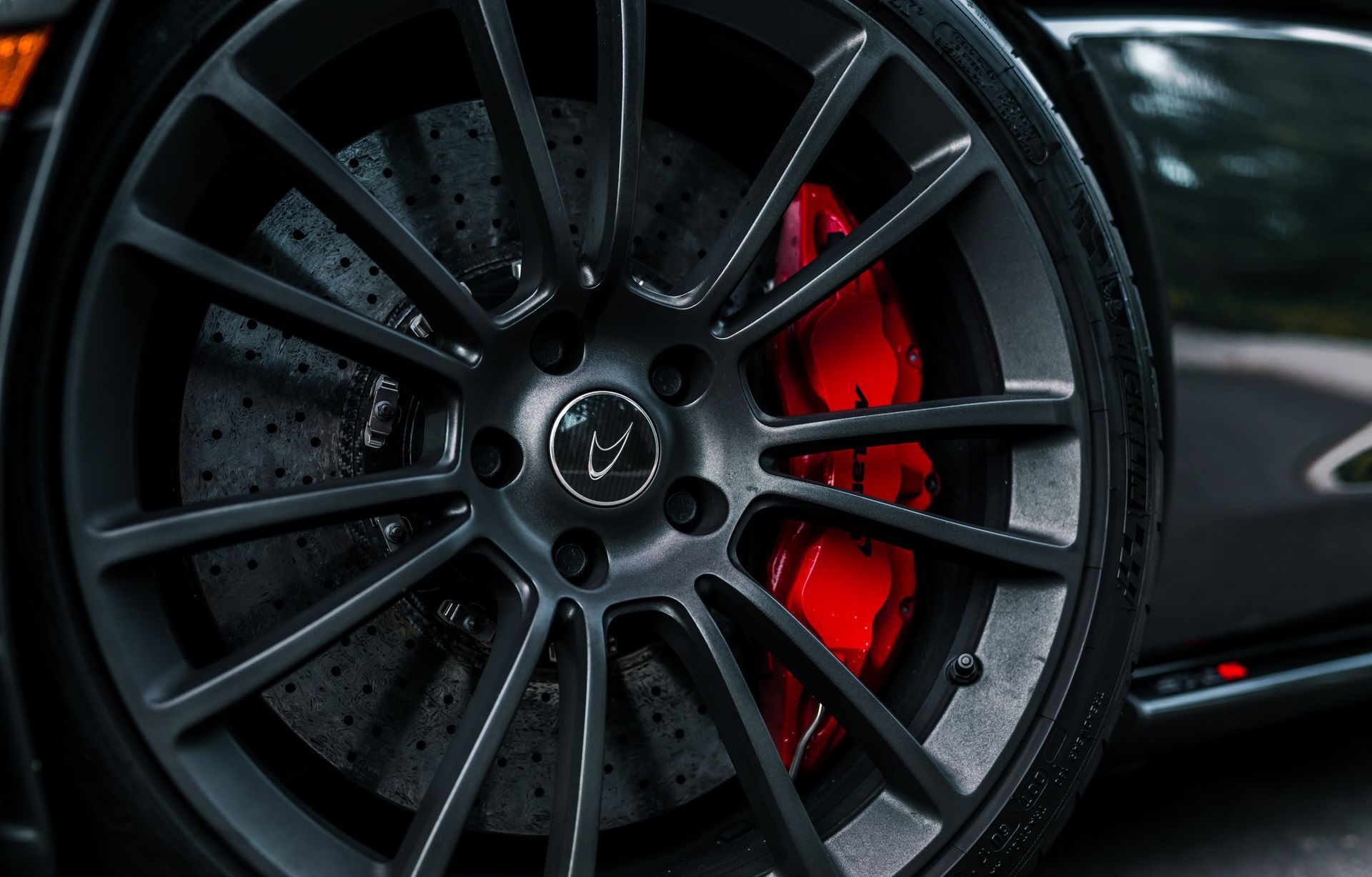 A close up of a car wheel with red brake calipers.