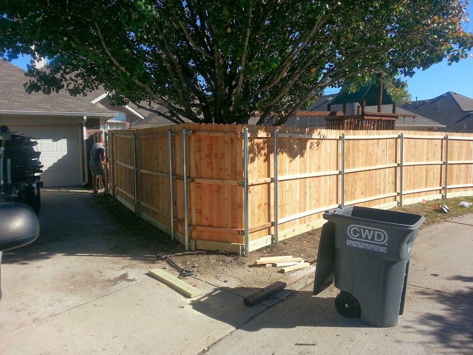 A wooden fence is being built in front of a house