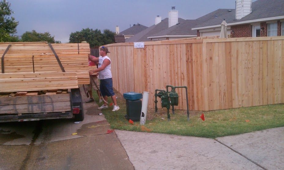 A wooden fence is being built in a residential neighborhood