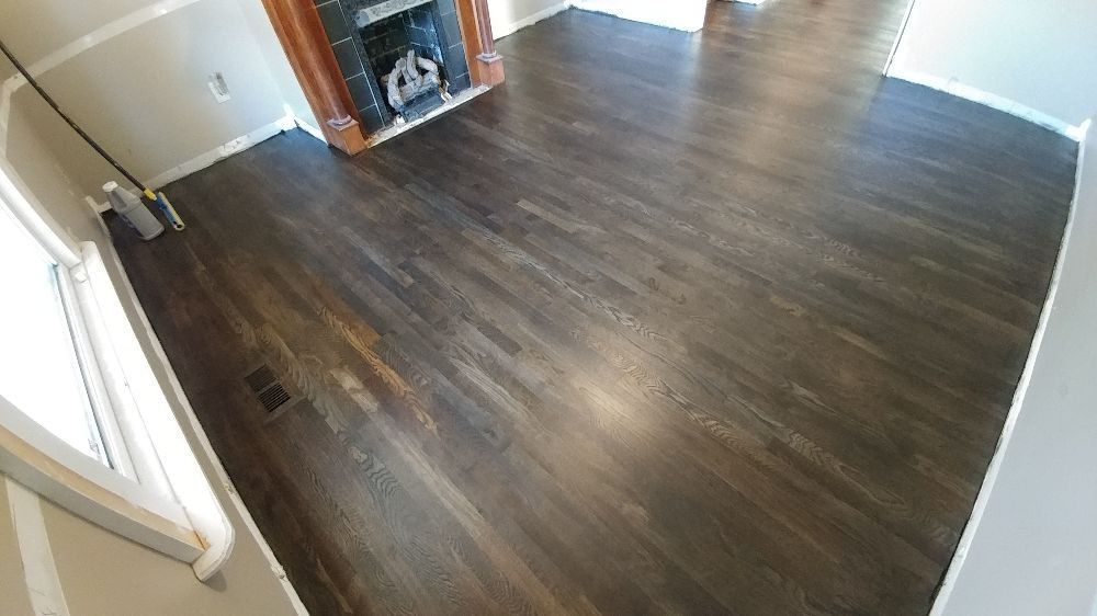 A living room with hardwood floors and a fireplace.
