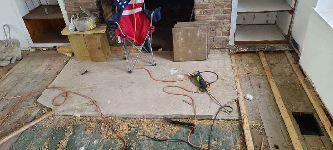 A living room with a fireplace and a rug on the floor.