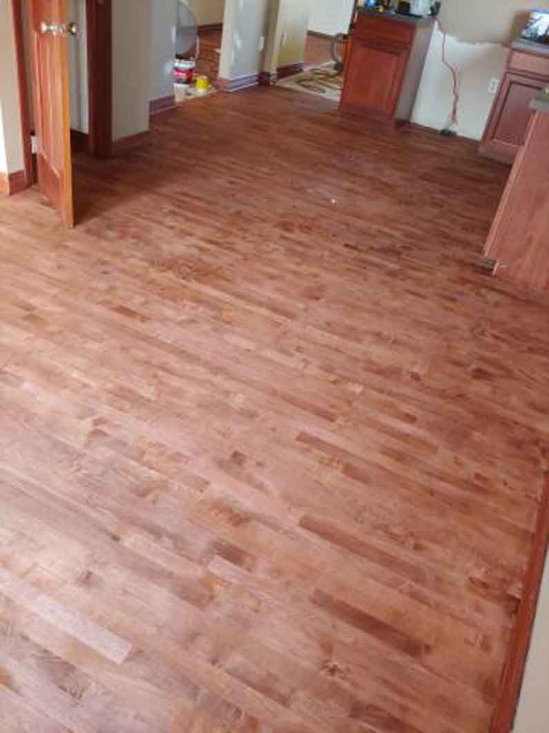 A living room with a wooden floor and a door.