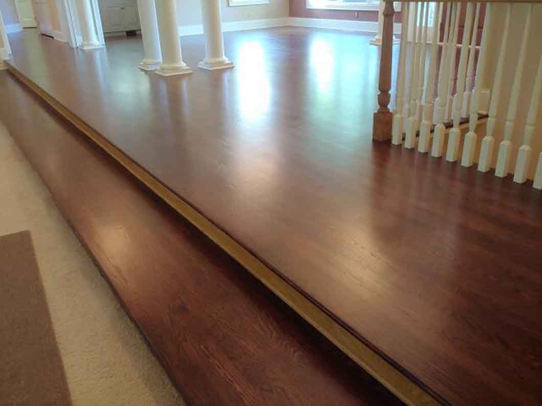 A wooden floor with a staircase in the background