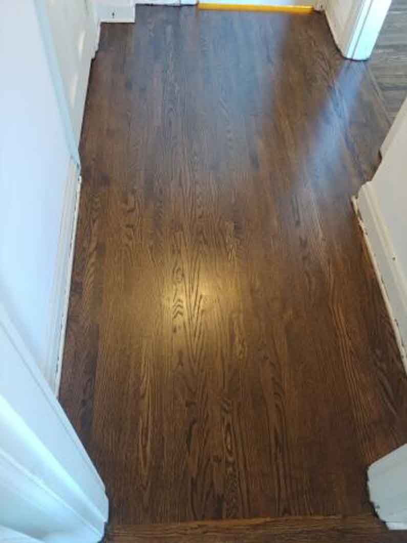 A hallway with hardwood floors in a house.